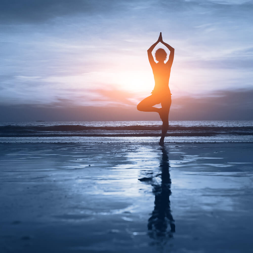 woman-doing-yoga-on-ocean-shore-mind-body